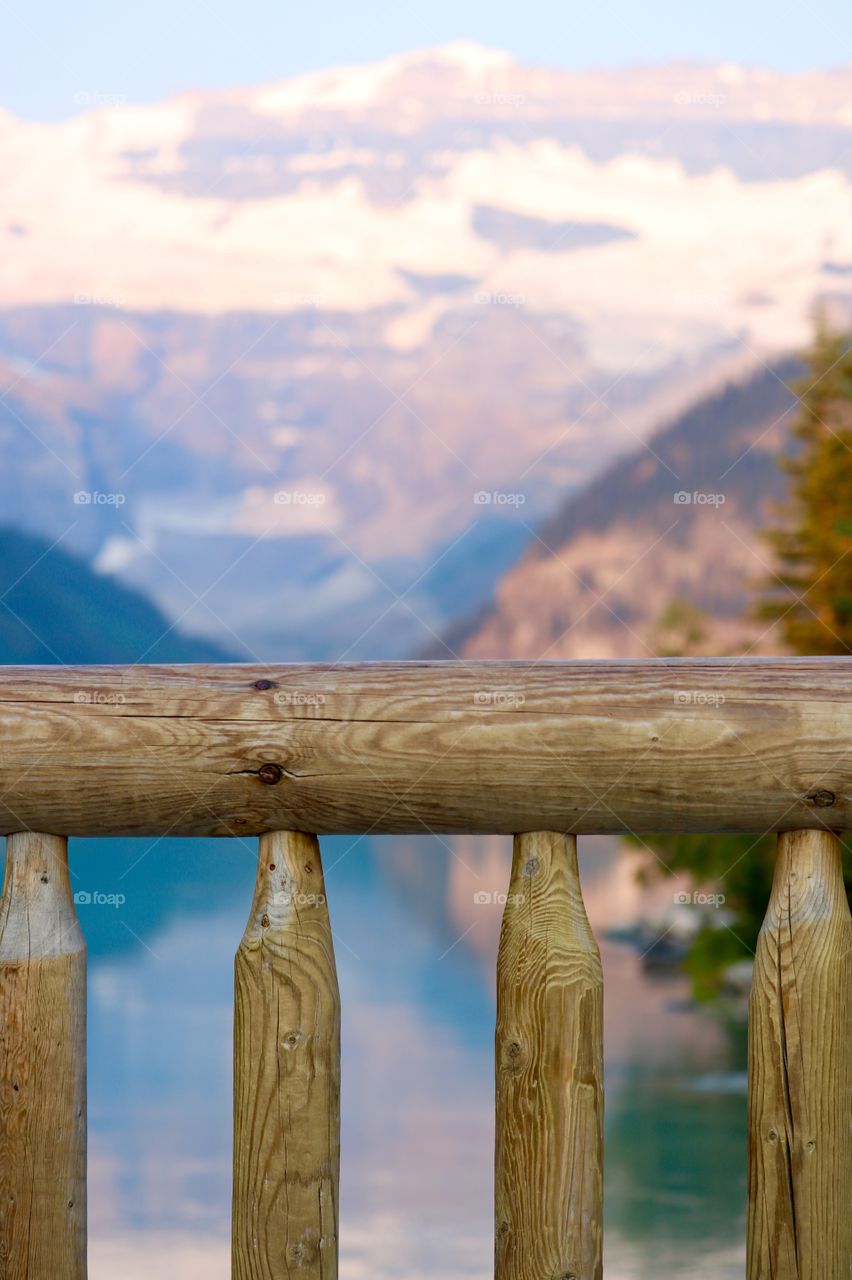 Scenic Lake Louise near Banff Alberta in Canada's Rocky Mountains, log fence in foreground 