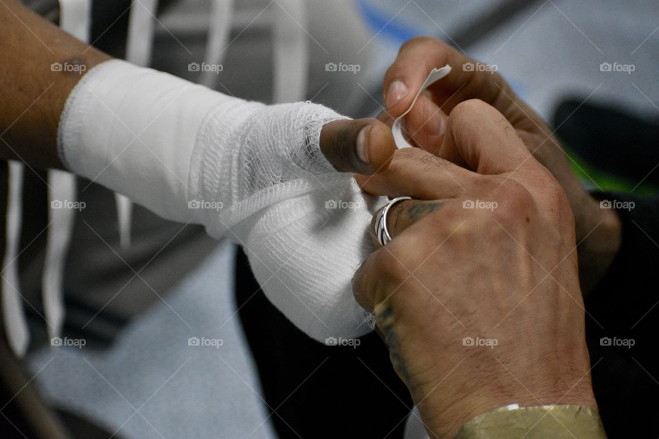 A trainer wraps the hand of his boxer before a Golden Gloves bout. 