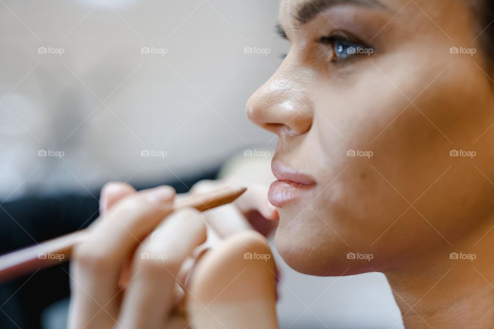 Makeup artist applies makeup to a woman.  Work in a beauty salon.  Professional cosmetics