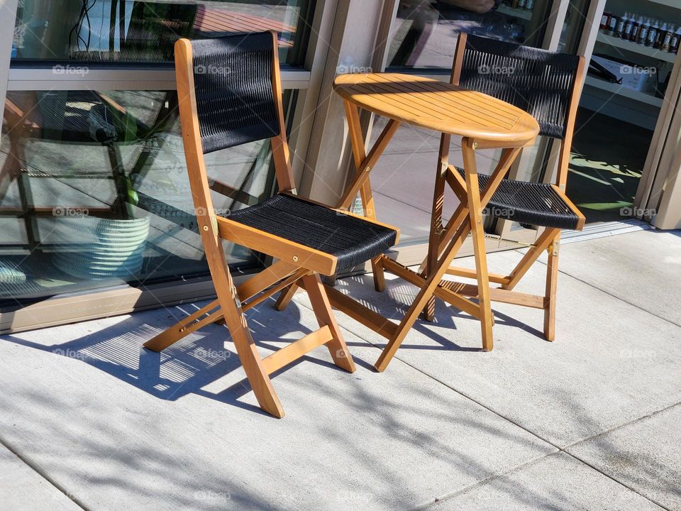 brown and black wooden table and chairs in outdoor shopping center