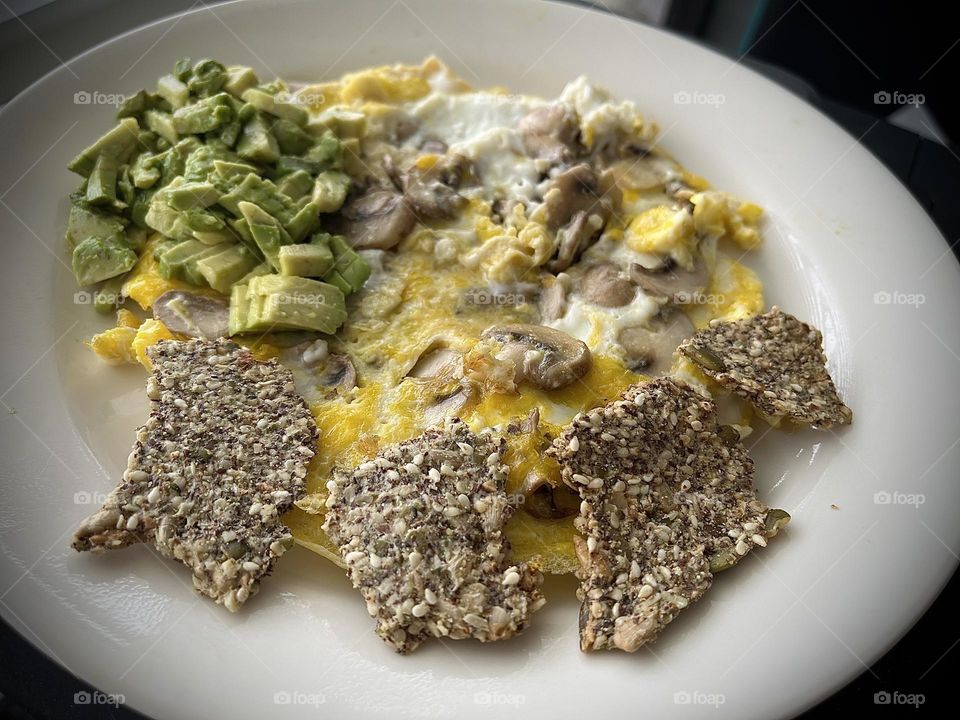 Healthy. Breakfast Eggs and mushrooms with avacado and homemade healthy nut crackers 