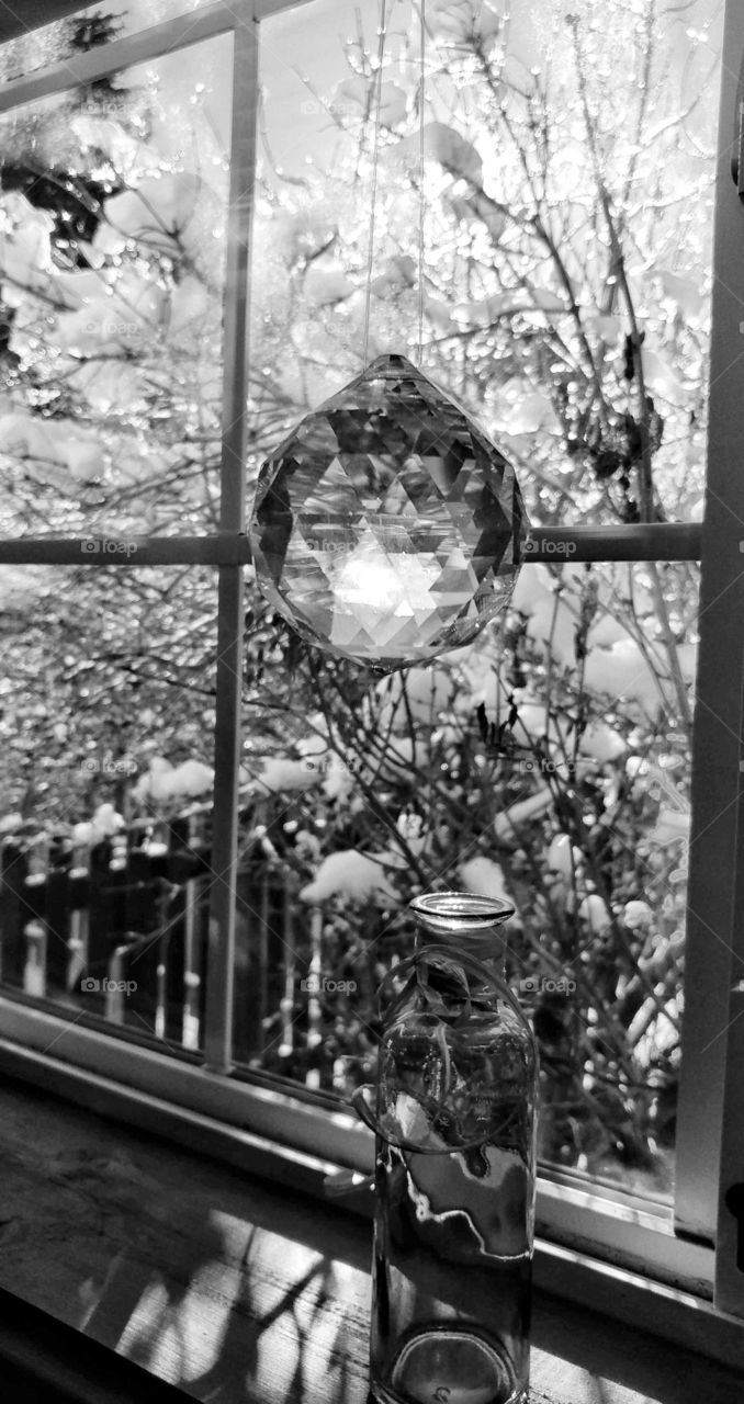Sunbeams of a winter day sparkling in the multi facets of a hanging crystal.