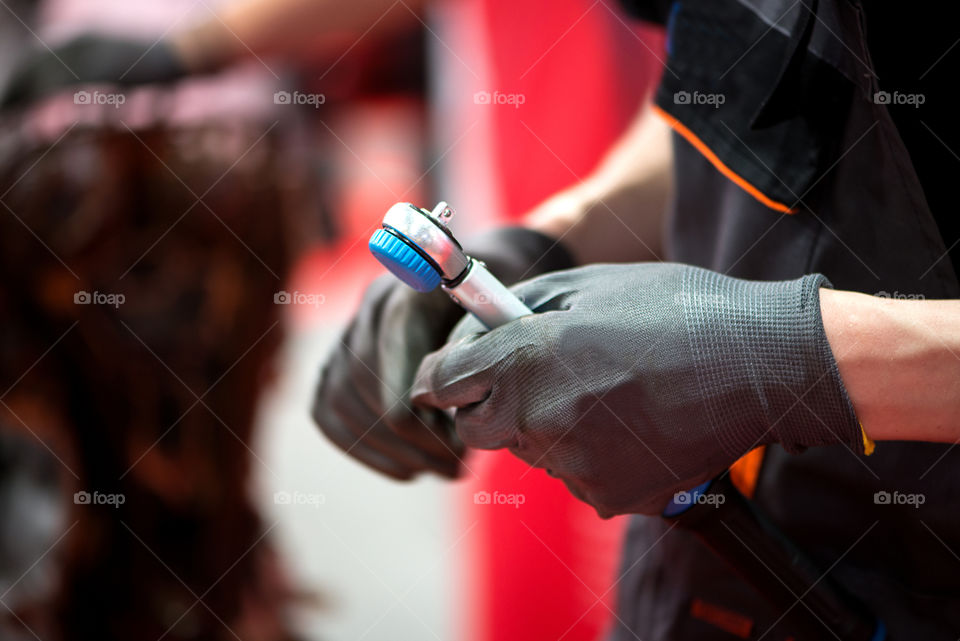 Mechanic holding instrument in auto repair service. Close up.