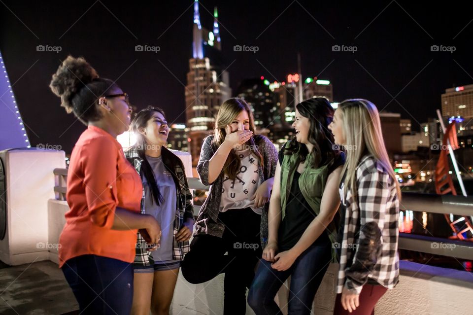 Girls on a bridge overlooking downtown Nashville at night