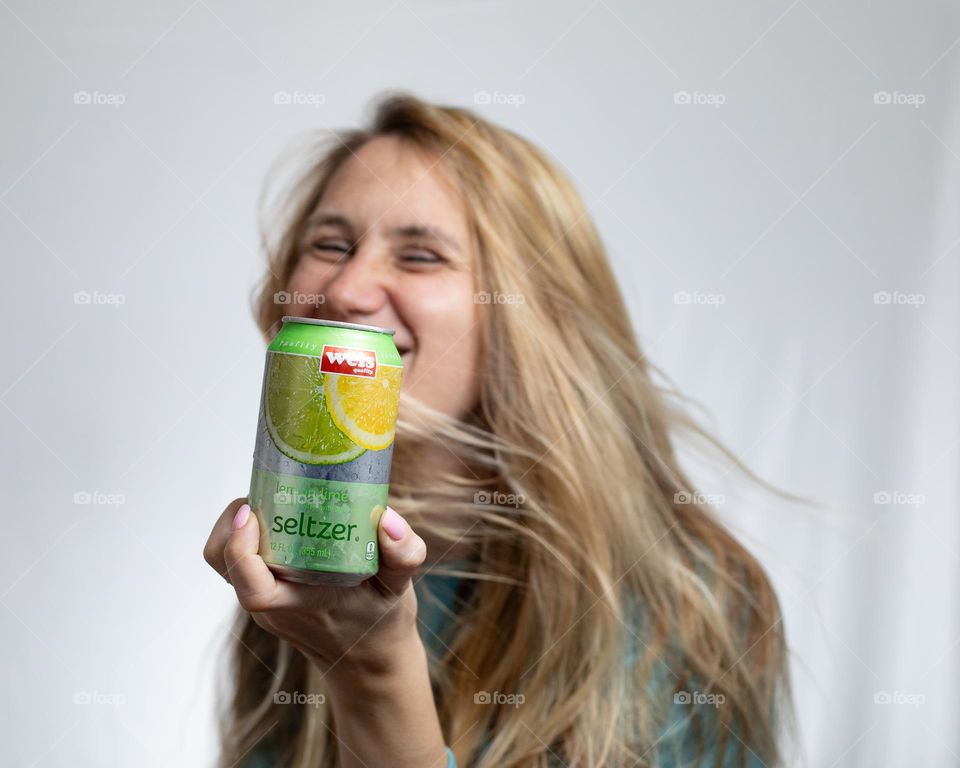 Woman happy with can of seltzer