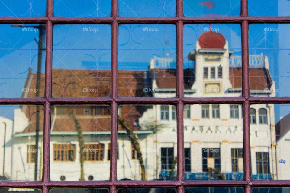 Portrait of a typical Dutch colonial heritage from the reflection of a window glass of a shop in the old city of Jakarta.
