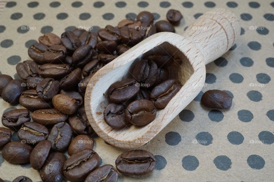 A scattering of coffee beans in a little wooden scoop 🤎