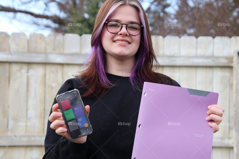 Teenager student with purple five star folder and study app