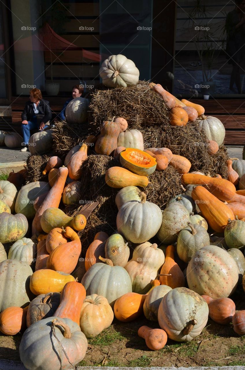 Pumpkins pile on hay stacks in street