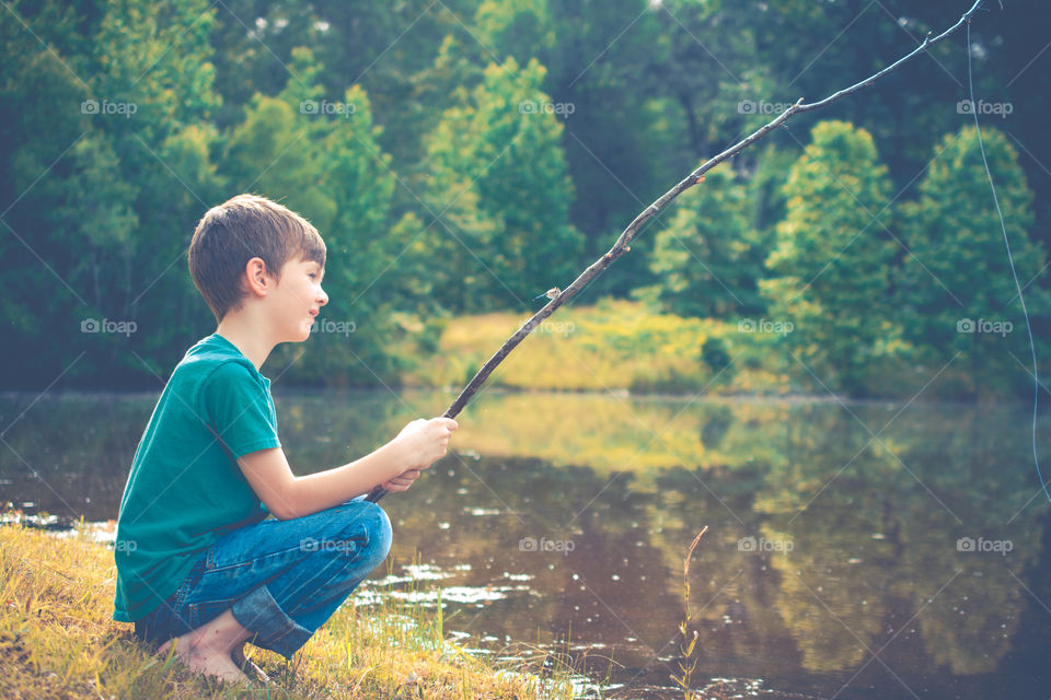 Young Boy Fishing by a Pond with Stick Pole 2