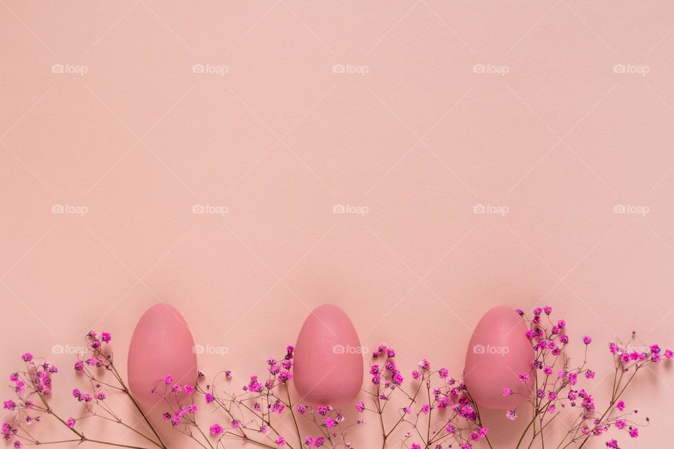 Top view of Easter mockup with pink eggs and twigs of gypsophila flowers on pink background