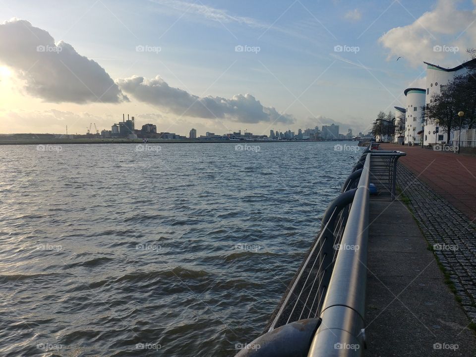 City in front of water with a perspective of the railings and buildings.