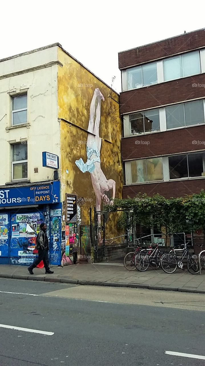 Painting of Man upside down across the road