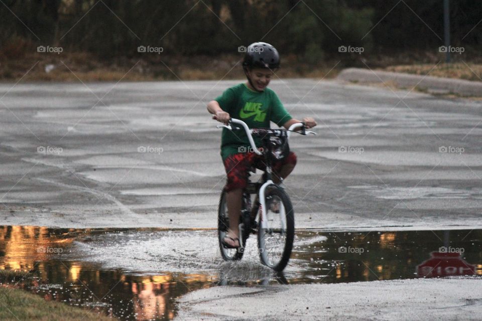 A boy and his bike. Boy riding bicycle through water 