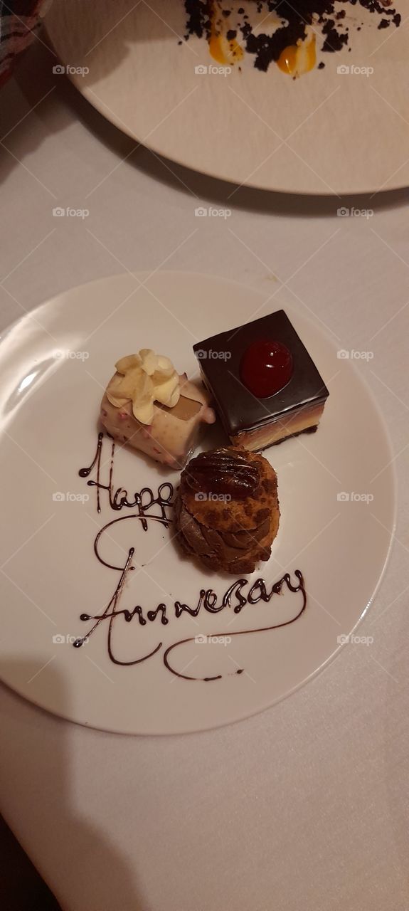 Happy anniversary trio of desserts chocolate square, profiterole and white chocolate, flat lay