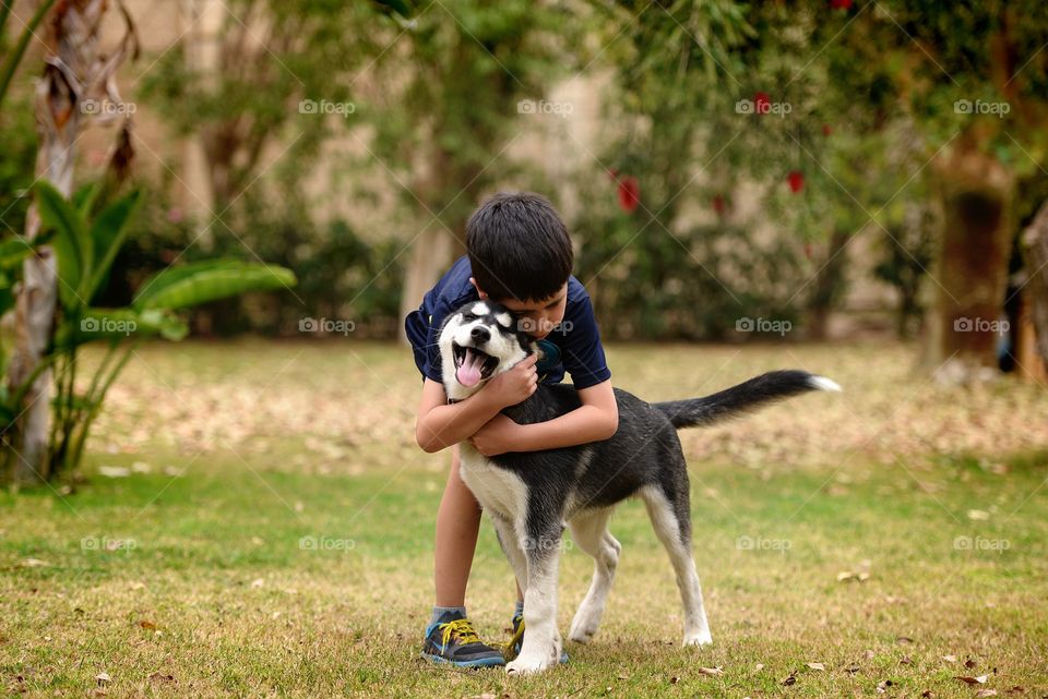 a boy hugging his puppy