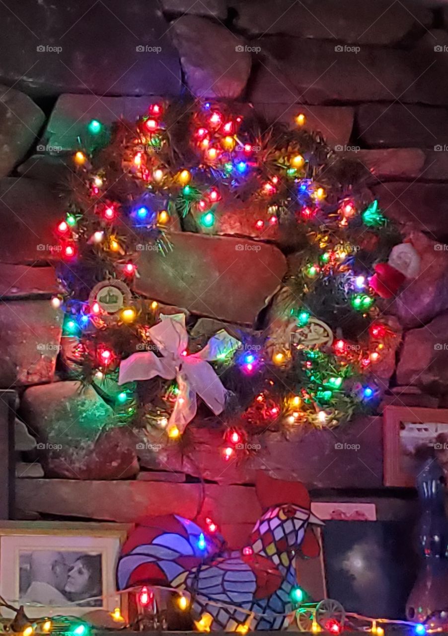 Christmas Wreath on fieldstone mantle, multicolored lights🎅🤶