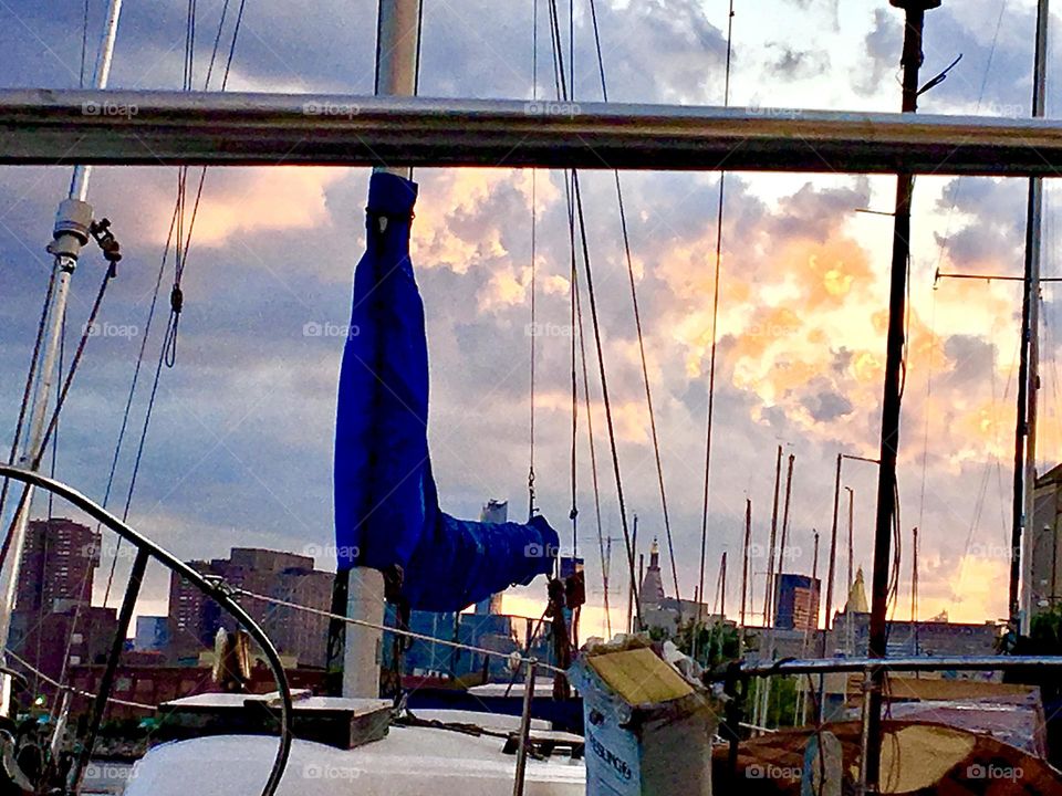An evening impression from aboard our sailboat “Salvation” looking out onto Newtown Creek in Long Island City, Queens, NY, its boats, various buildings on the shoreline and a beautifully colored sky at dusk. 2021. Hypnotic Productions