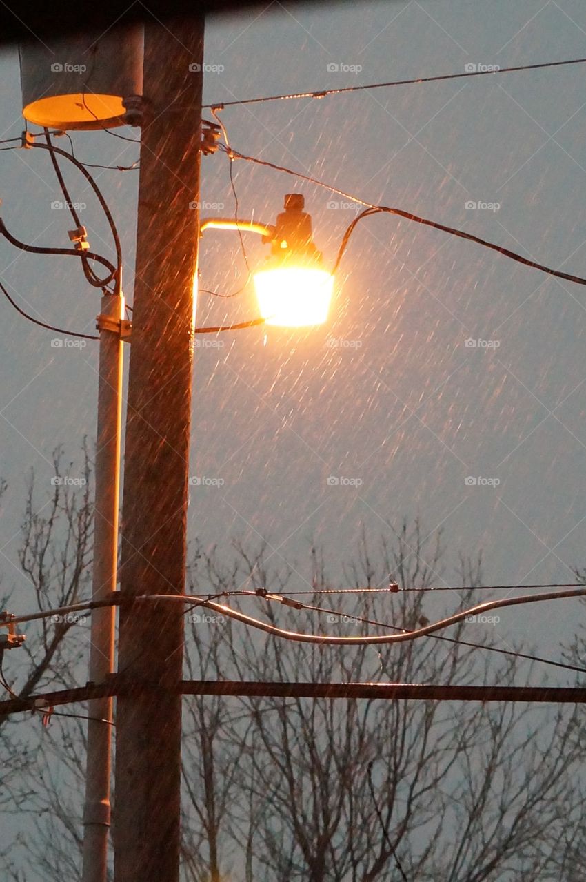 Yellow light shines thru rain. Storm 