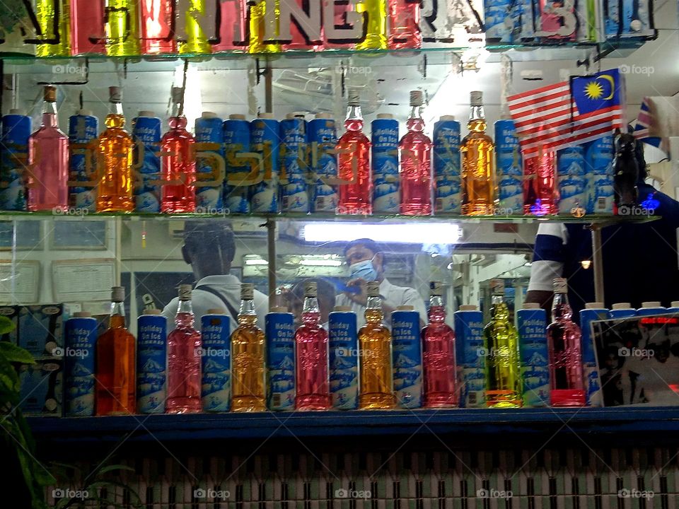 A traditional barber shop that decorates its storefront with colourful glass bottles and powder cans.