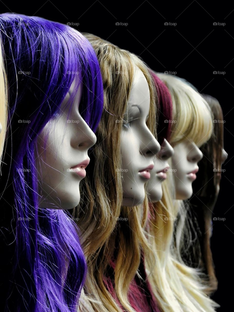 Coloured wigs adorn mannequins in beauty parlor