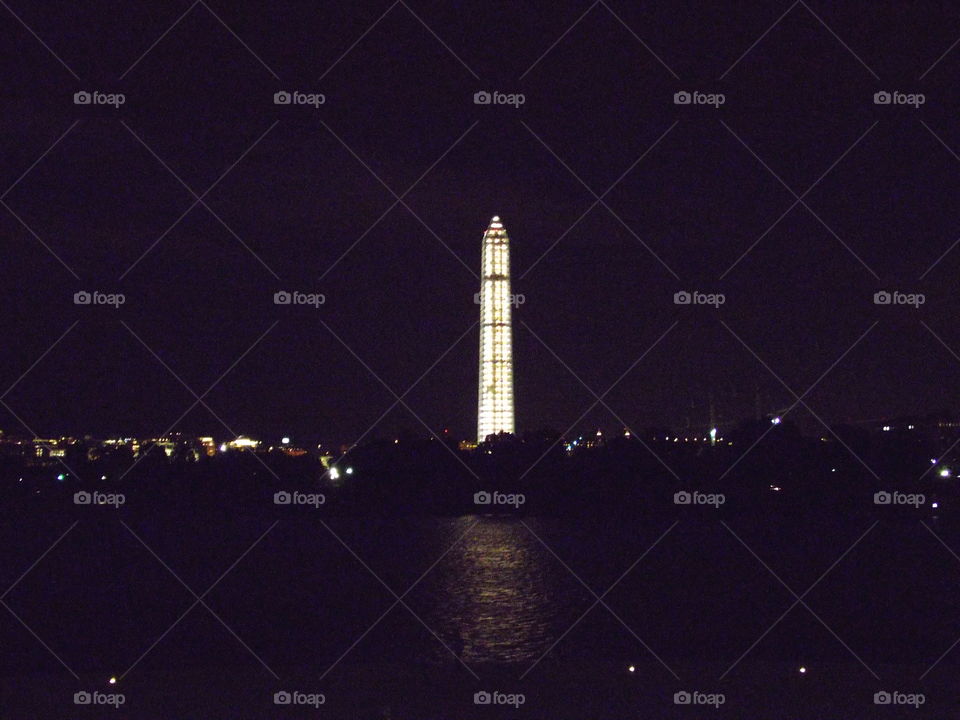 Scaffolded and illuminated Washington monument from the far end of the mall in Washington DC