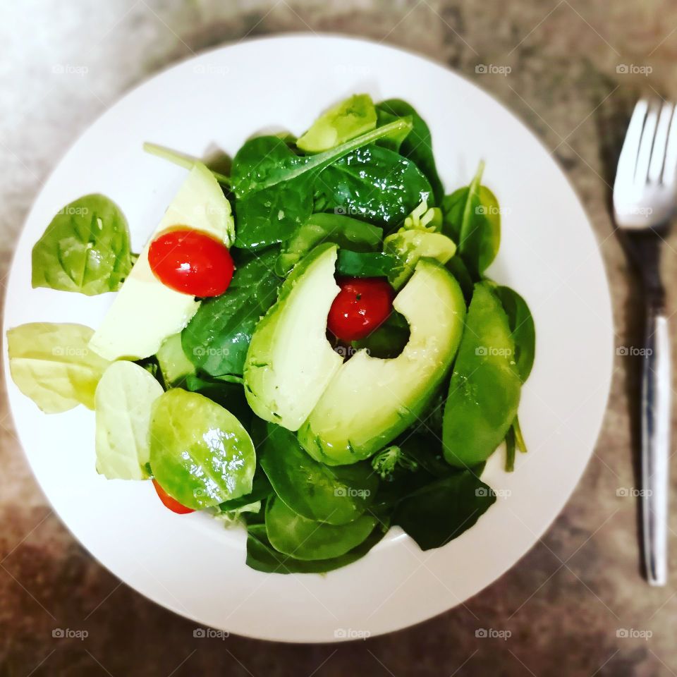 A fresh green salad with a Vaca do spinach and tomato, finished with an apple cider vinegar dressing