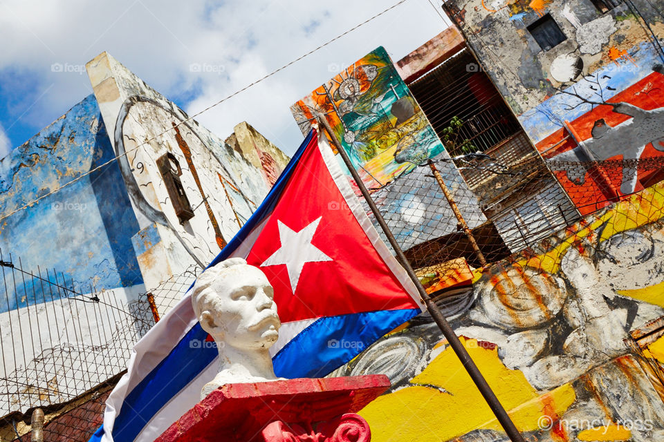 Cuban Flag and Graffiti . Looking up at wall with graffiti in Havana Cuba 