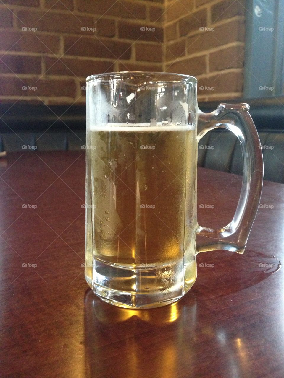 Ice Cold Beer . Mug of cold beer on a table inside a restaurant 