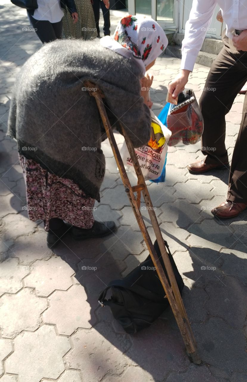 This old lady has a hard time to stand still. As you can tell she is very poor. My colleague gave her a little bit of money.