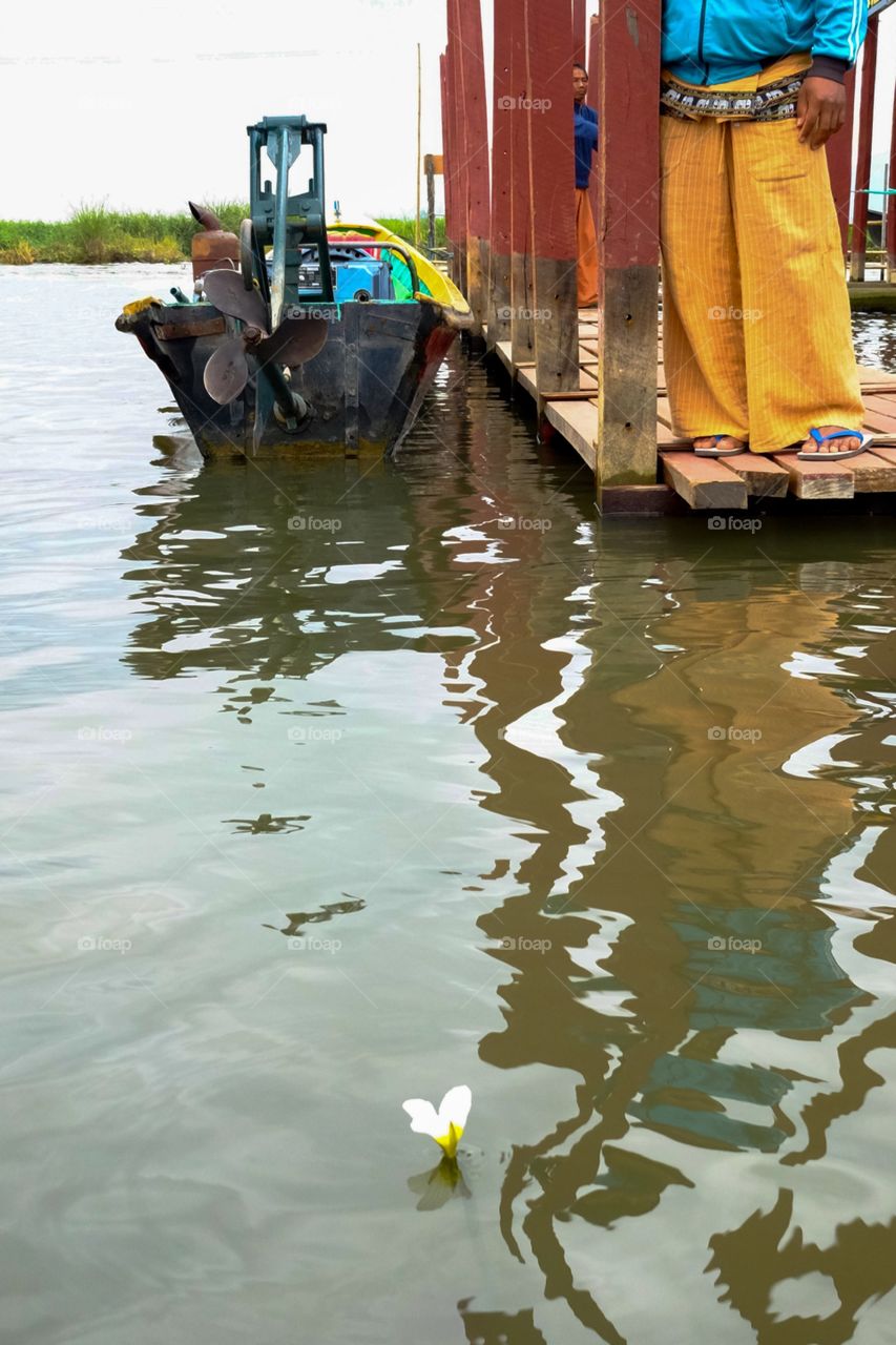 A boat, longyi and a flower