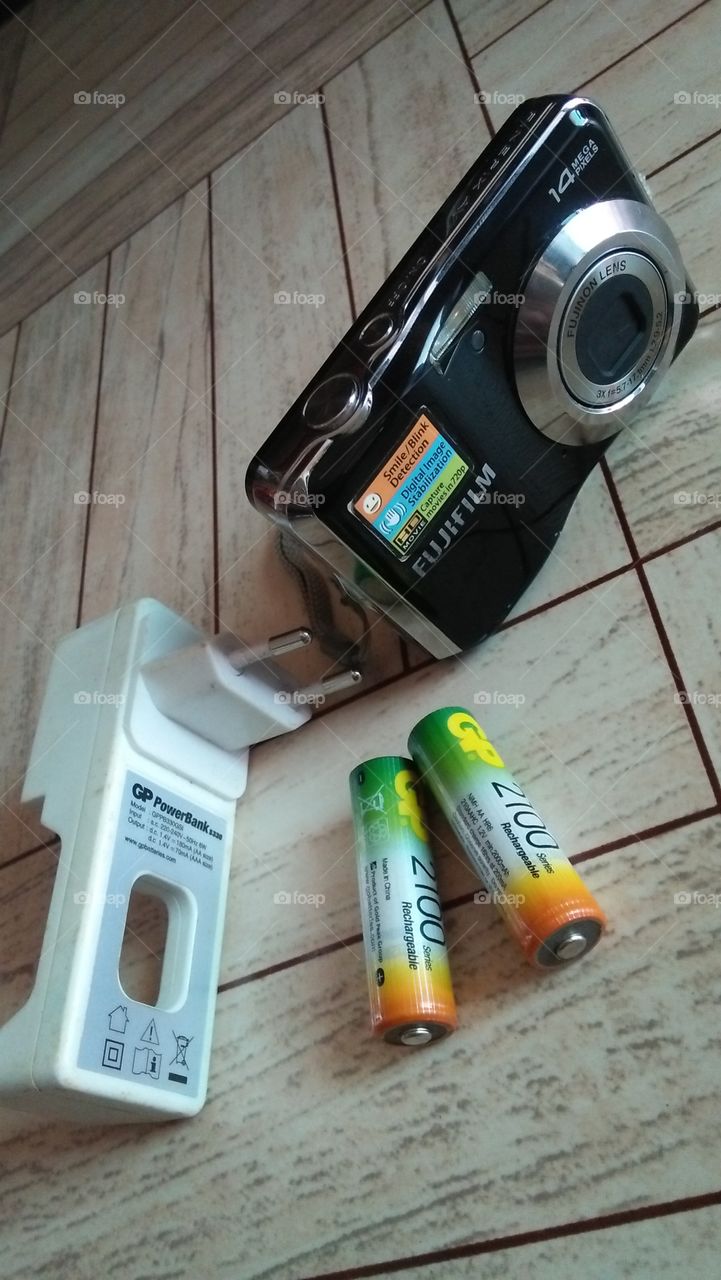 Fujifilm camera with cells and charger.