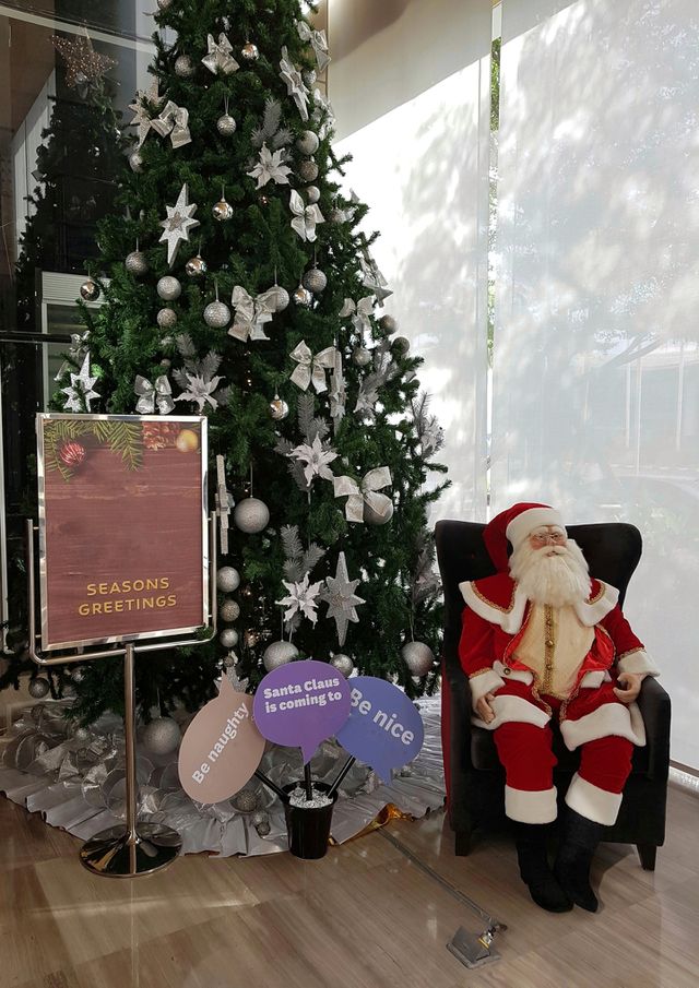 Santa claus sitting by a christmas tree
