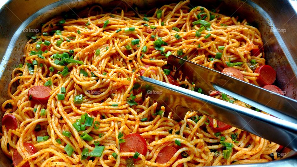 Macarrão com extrato de tomate, cebolinha e salsichas.