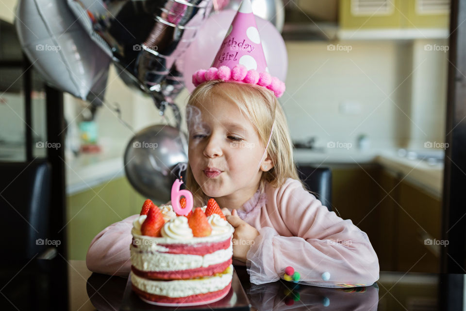Birthday girl blowing candle on cake