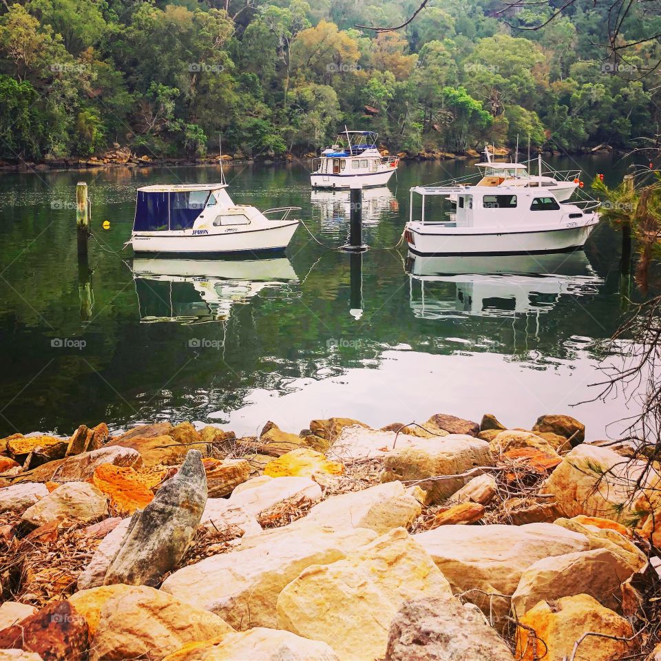 Boats on the water with rocks 