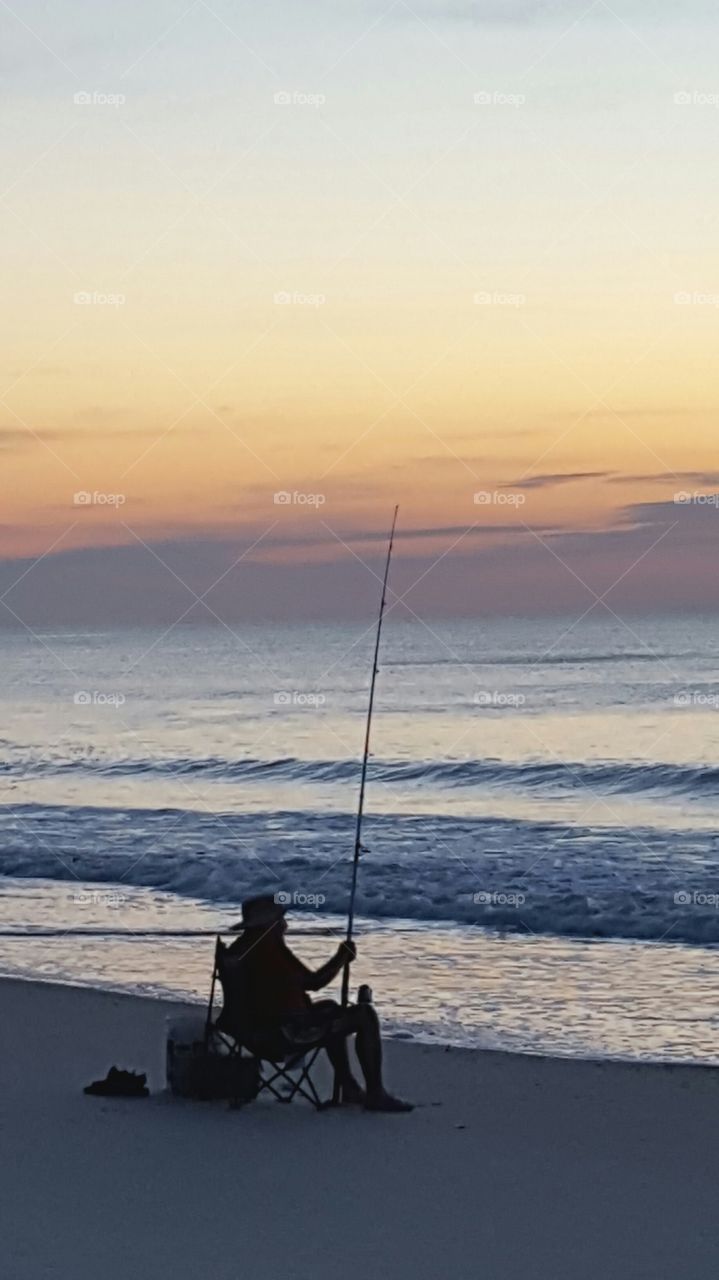 fishing on the shore at dawn