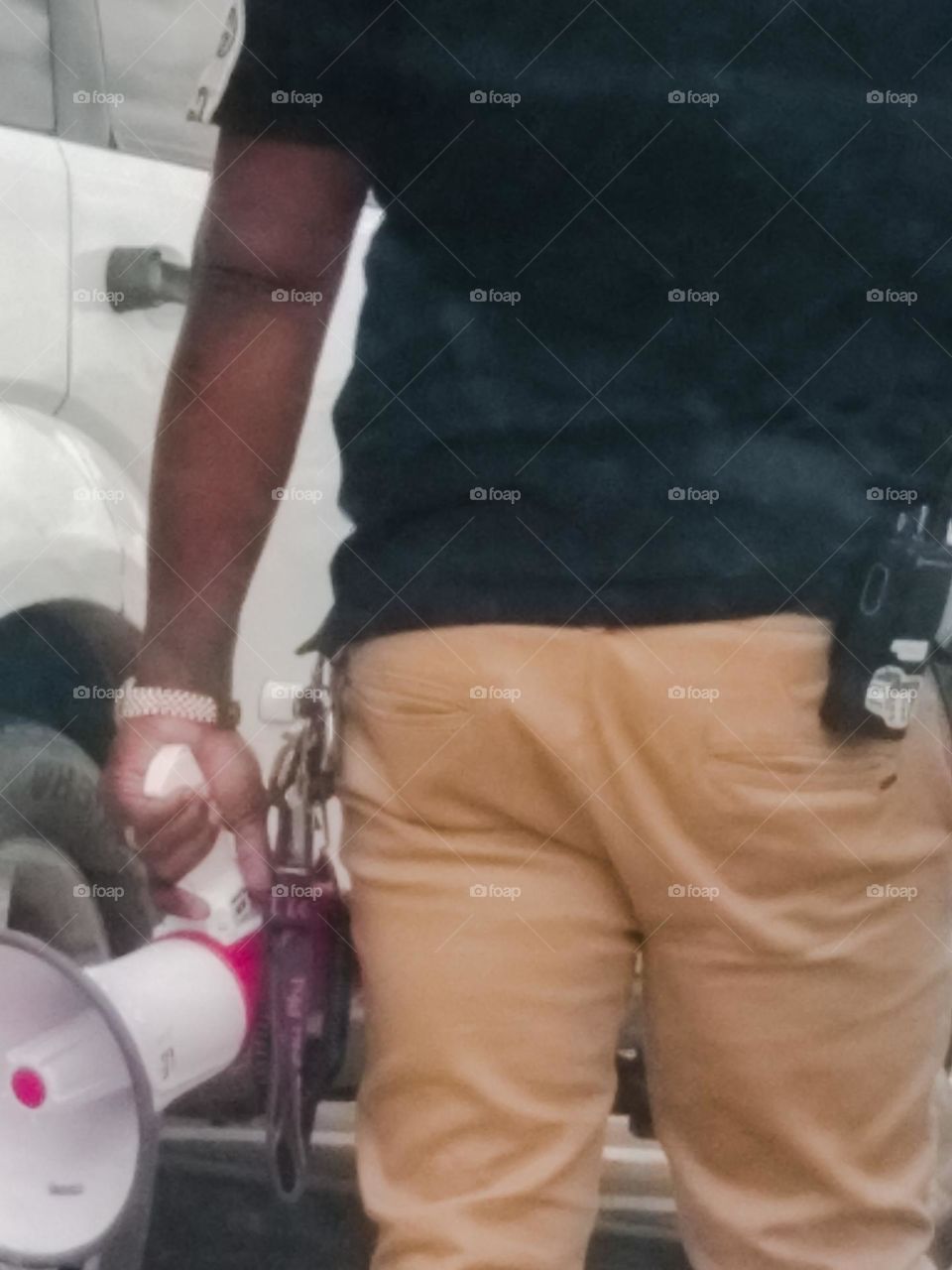 An interesting view of a male school worker with a 📣 megaphone, walkie talkie and keys on his belt.