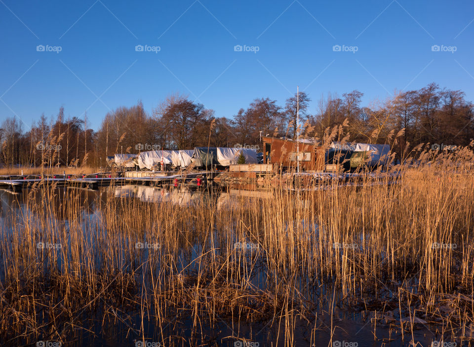 Winter landscape scenery in Helsinki, Finland with Baltic Sea and marina and boat in winter storage covered by tarpaulin on the background on 27 December 2015