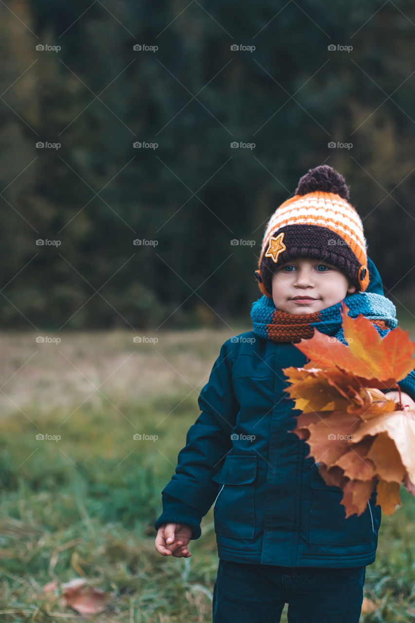 boy plays with leaves