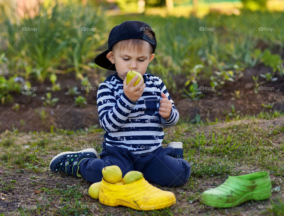 boy playing and eating pears