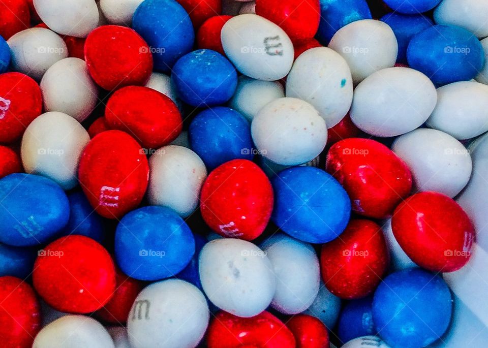 M & M’s in patriotic red, white, and blue, close up down in the bag 