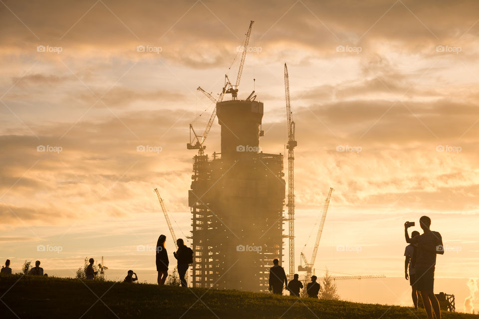 silhouettes of people and building under construction