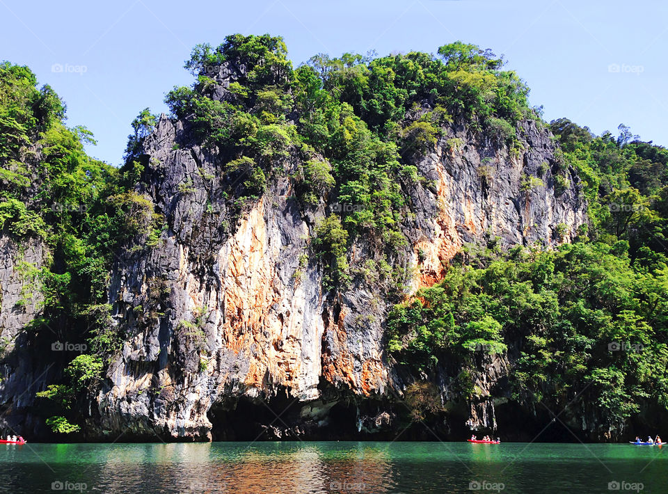 Swimming in boat under the beautiful tropical rocks