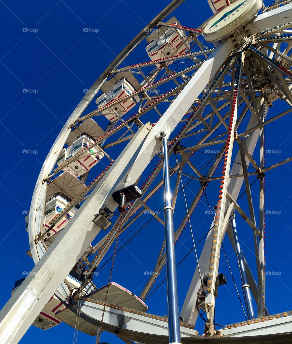 Close up of Ferris wheel against clear vivid blue sky