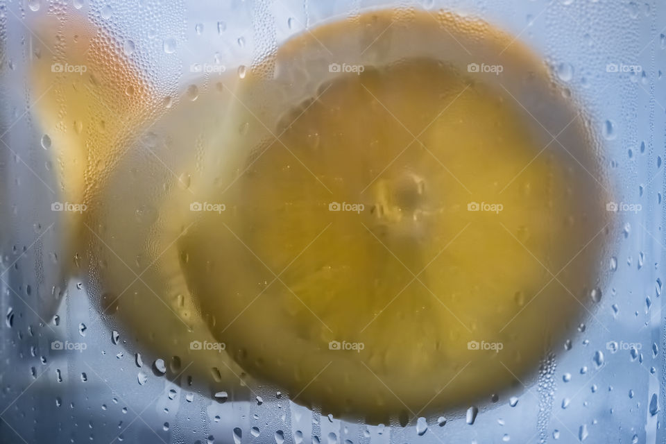 Lemon slices placed inside a jug of cold water - for that refreshing drinking experience on a warm day. Focus of image is on the external condensation beading