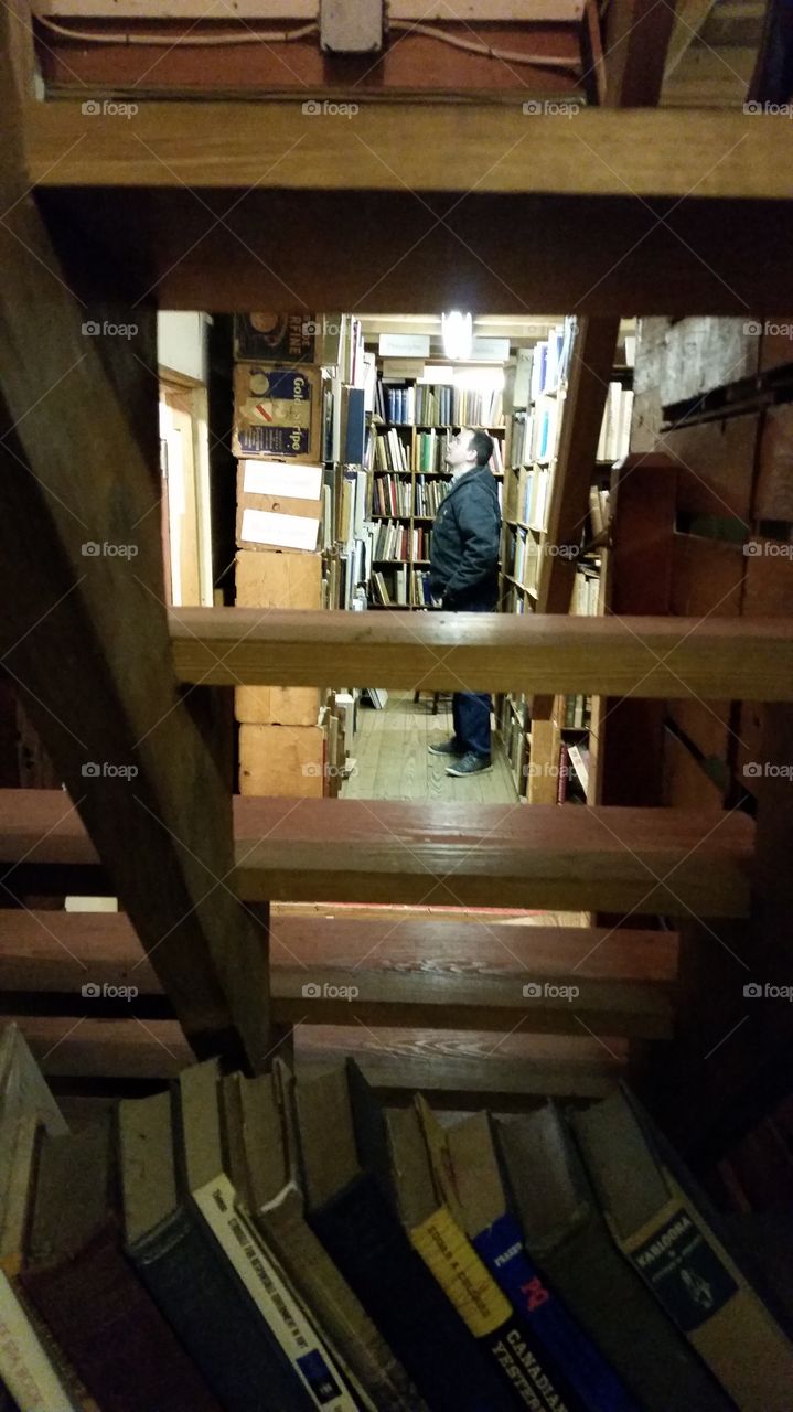 He's just perusing. Walking through the most interesting bookstore in a refurbished barn, where all the shelves were made out of old merchandise creates. And the exposed stairs made for a nice shot.