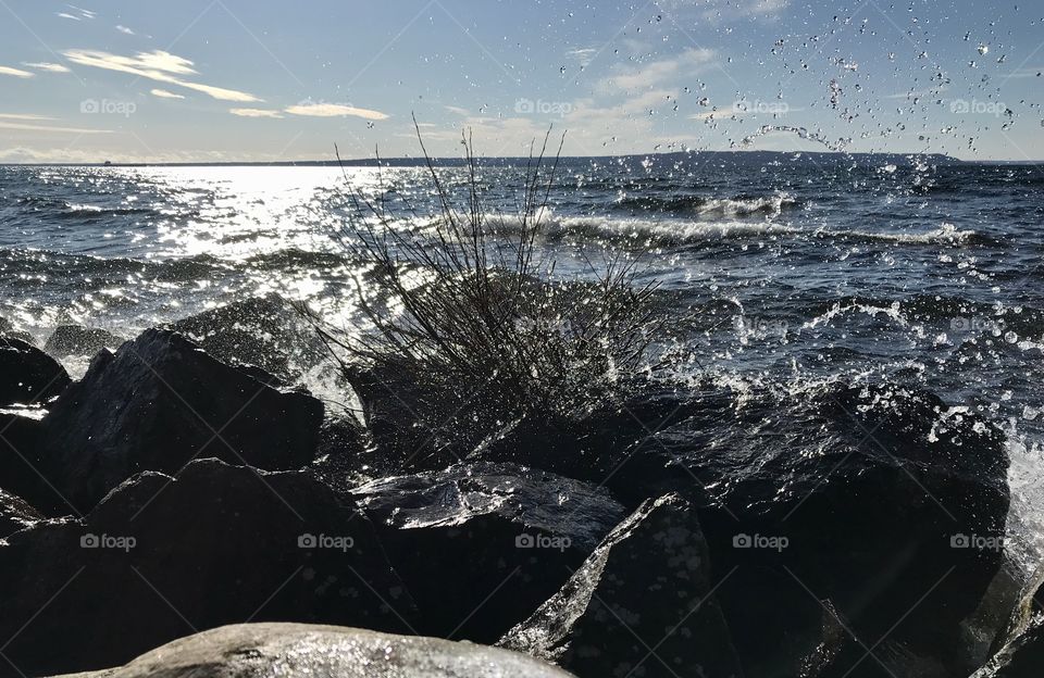 Water splashing against rocks along a lake side