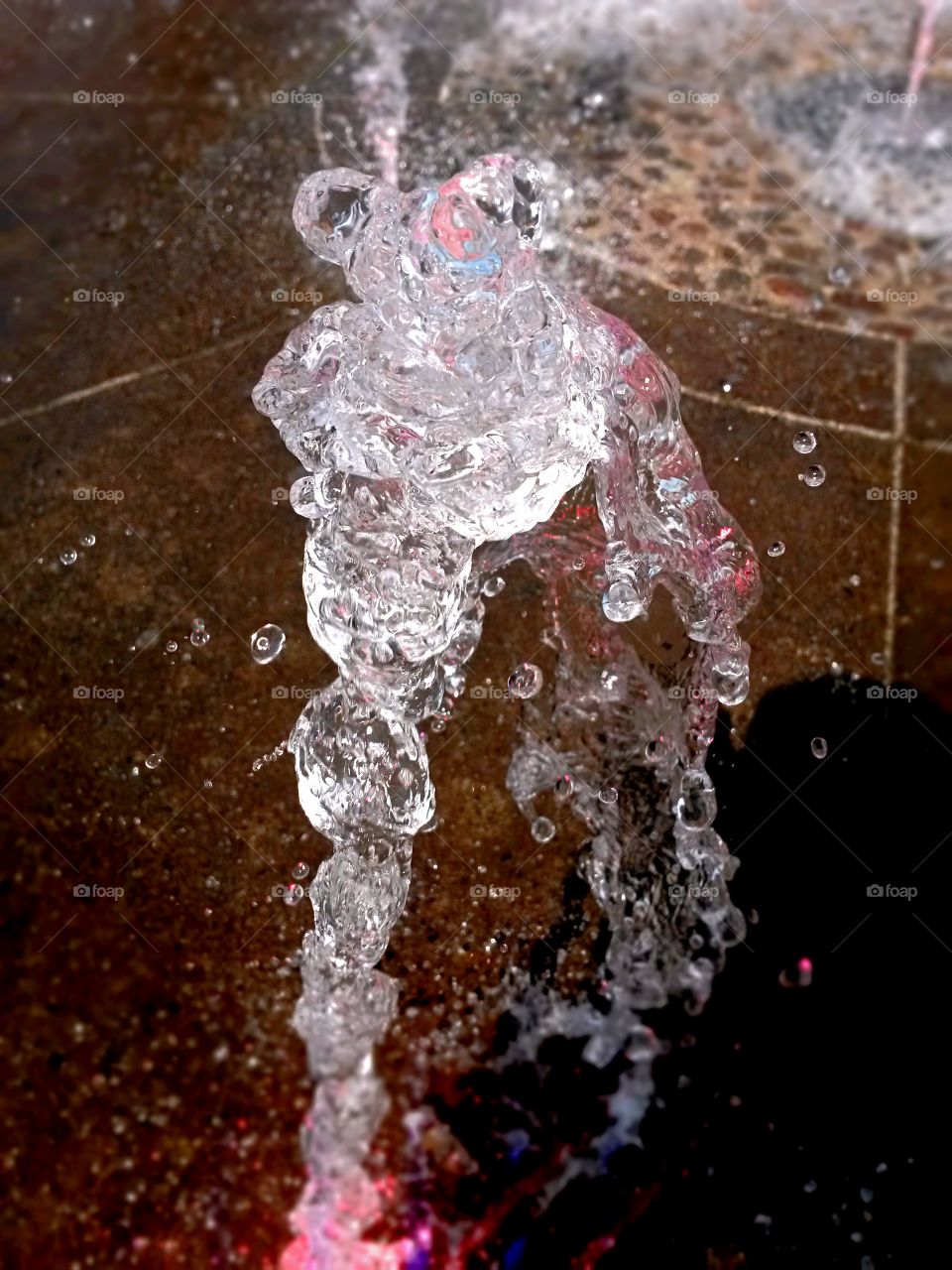 water in motion: Close up of water splash from a fountain with colored light