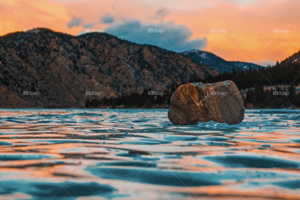 Rock on frozen lake 